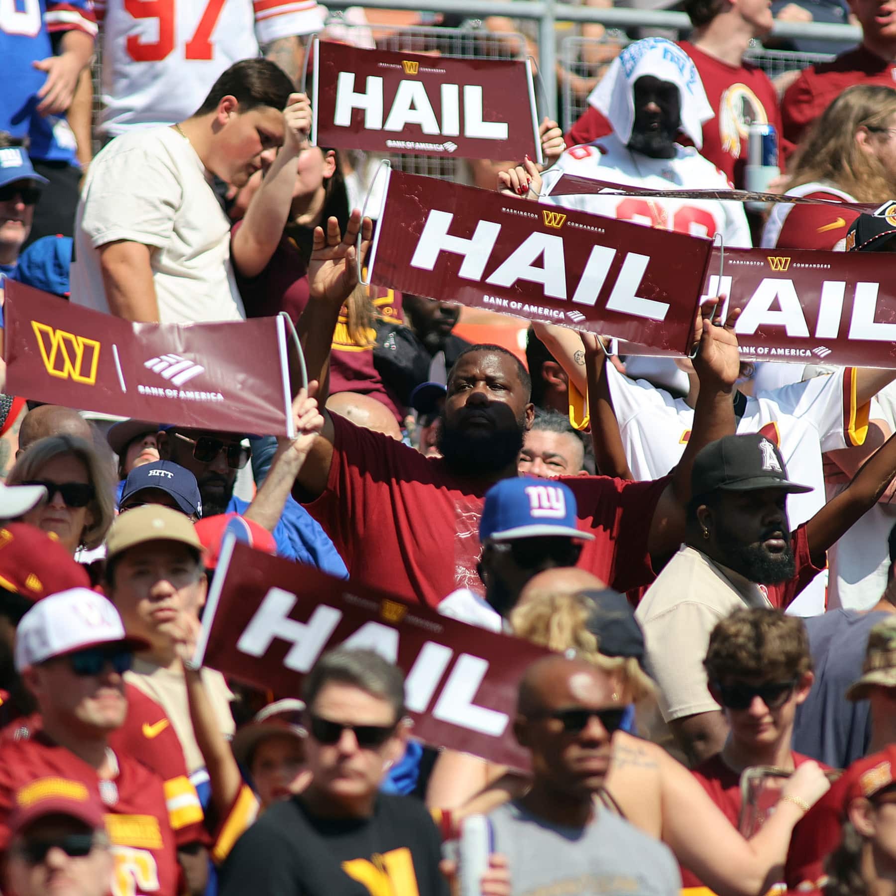 Fans waving branded HAIL rally signs at a stadium